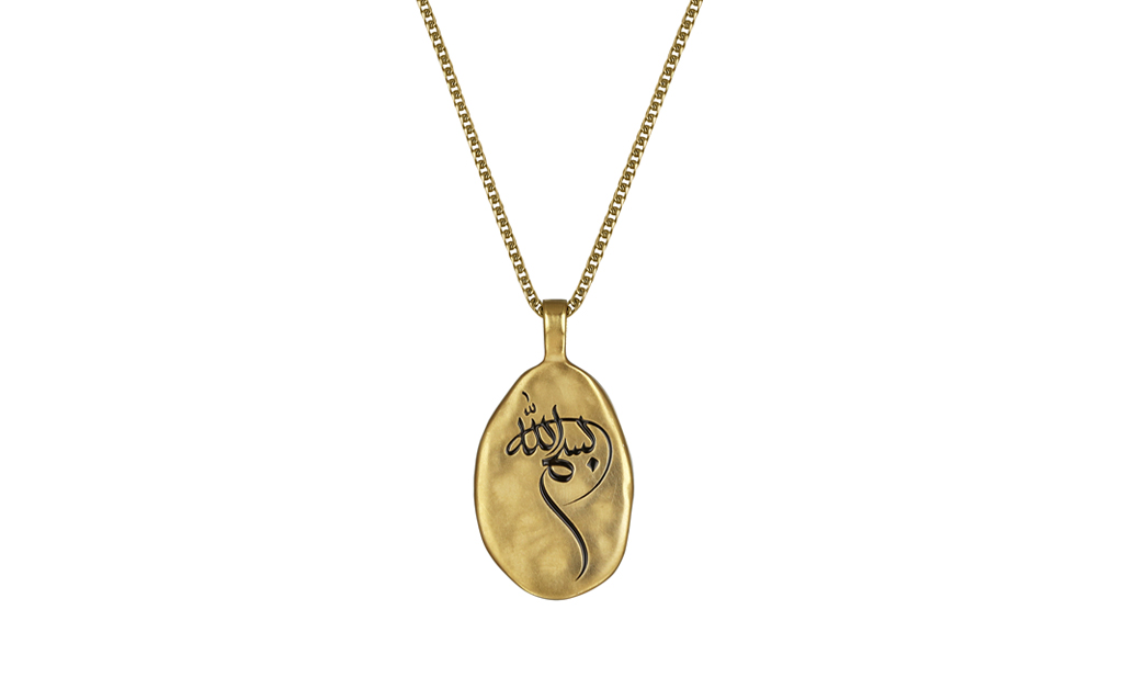 The basmala appears in all its splendor, engraved on this yellow gold pendant, which is distinguished by its artistic oval shape, asymmetric and hand-crafted line
